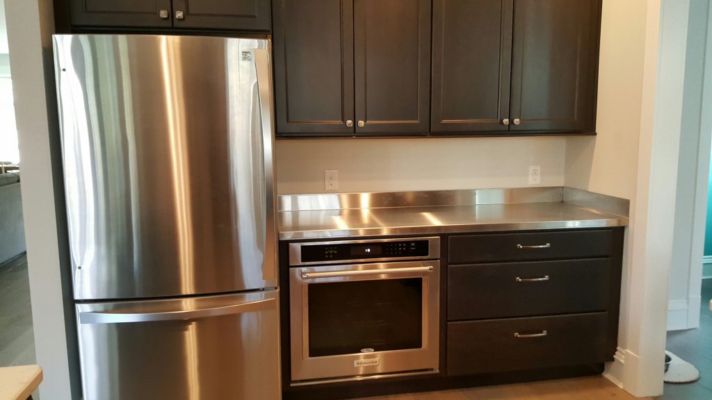 Stainless steel counters provide a sleek and modern look to this kitchen. 