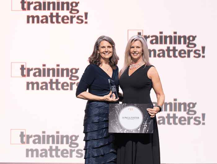 Julie Frank and Lee McGinnis, who lead Long & Foster's training programs, accept the Training APEX award on the company's behalf.