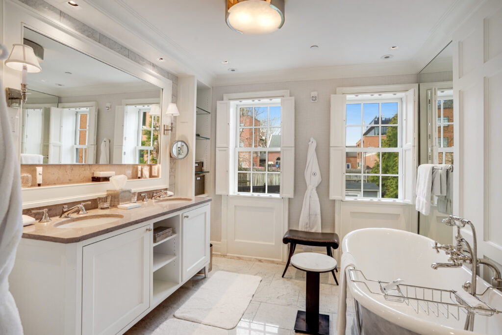 The spa-like primary bathroom is complete with a deep-soaking tub, walk-in rainforest shower, and heated marble floors.